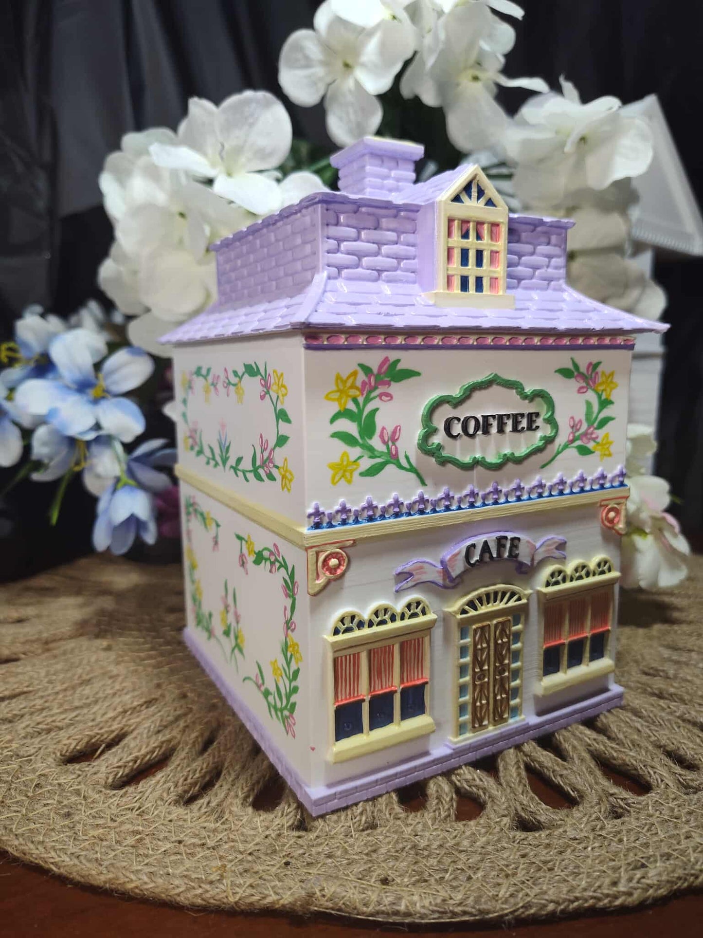 Decorative coffee-themed building with flowers in the background