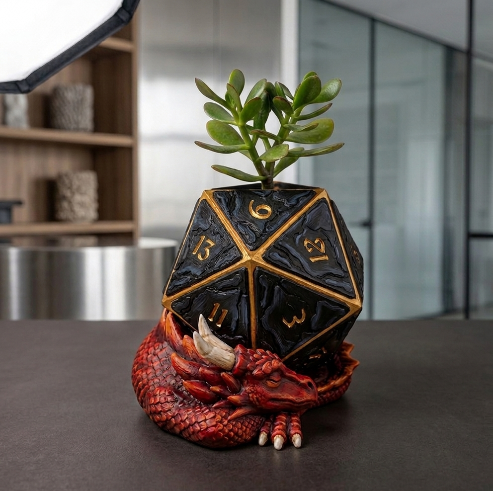 Black and gold polyhedral die-shaped planter with succulent on a red dragon base in an office setting.